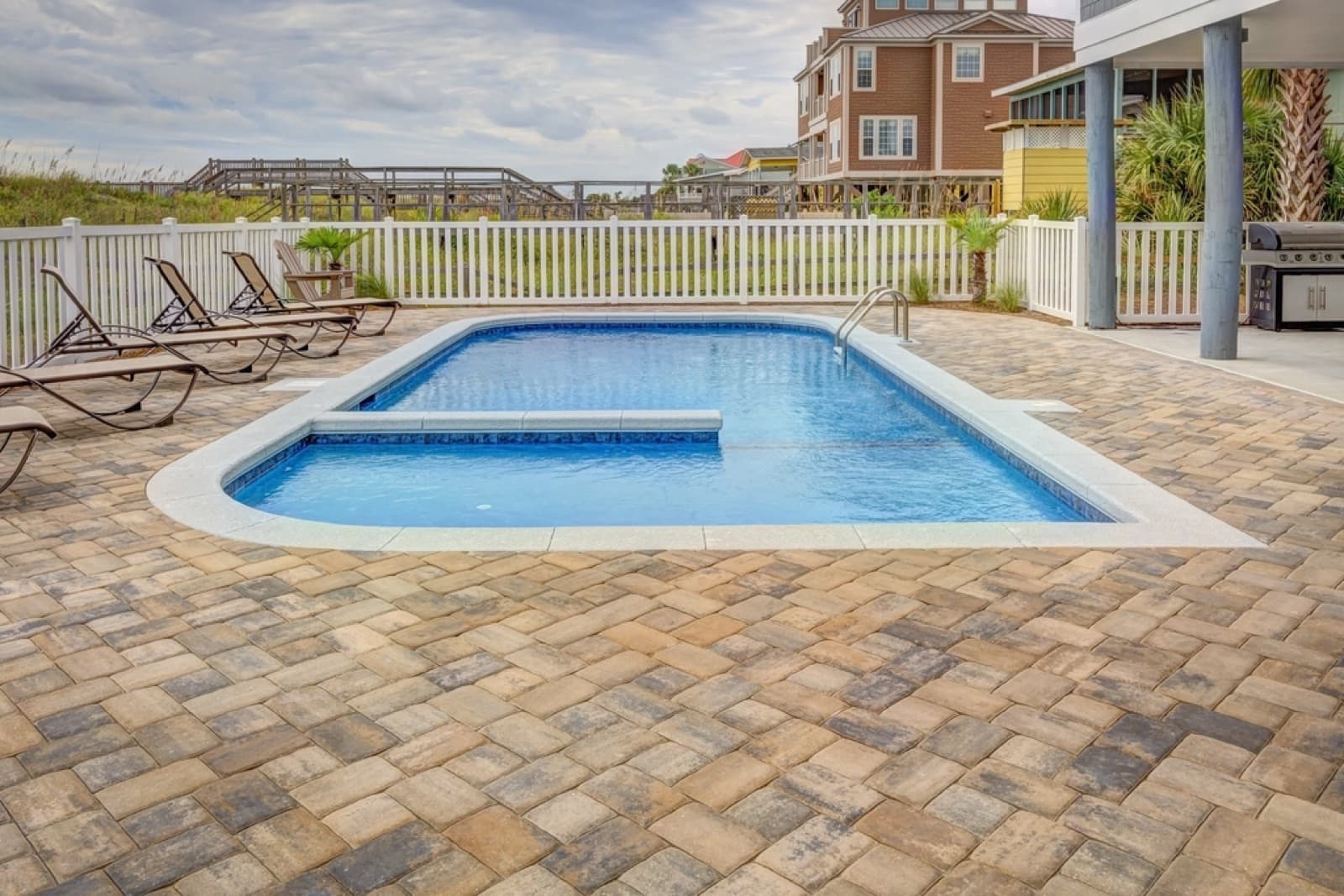 Backyard swimming pool with a clean paver pool deck